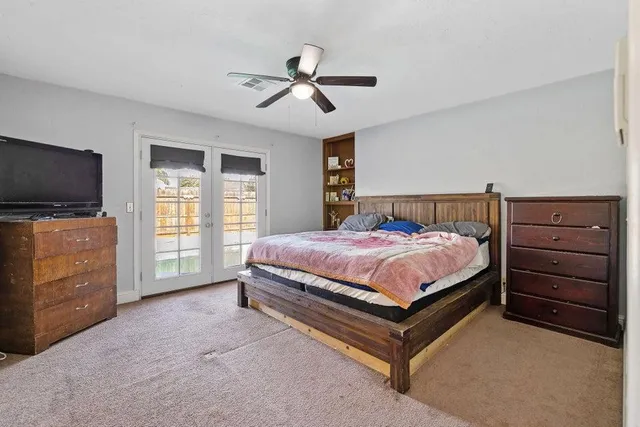 a spacious bedroom with a bed and flat screen tv