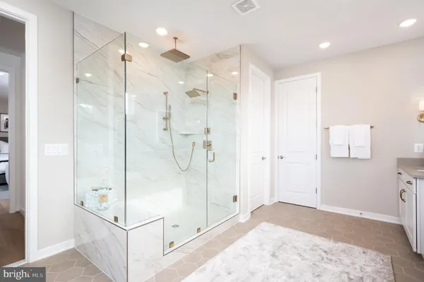 a bathroom with a glass shower door and a sink
