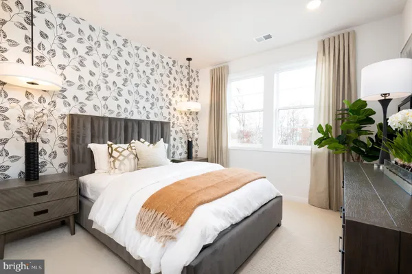 a bedroom with a large bed and a potted plant