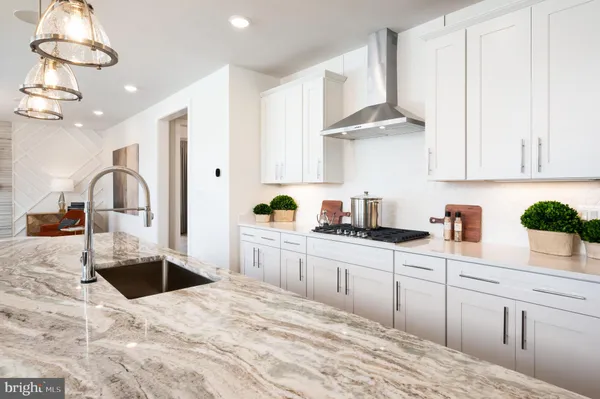 a kitchen with kitchen island granite countertop a sink stainless steel appliances and cabinets