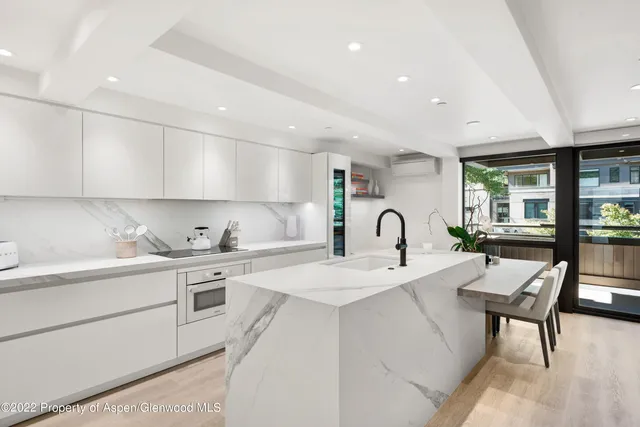 a kitchen with white cabinets appliances and a sink