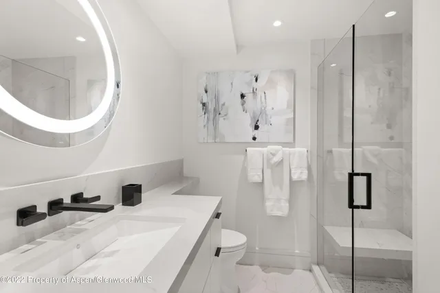 a bathroom with a sink a toilet and a mirror