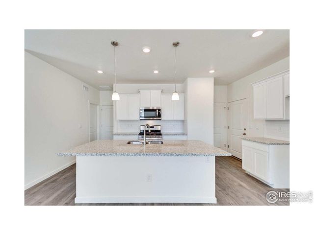 a open kitchen with stainless steel appliances kitchen island granite countertop a sink a stove and a refrigerator