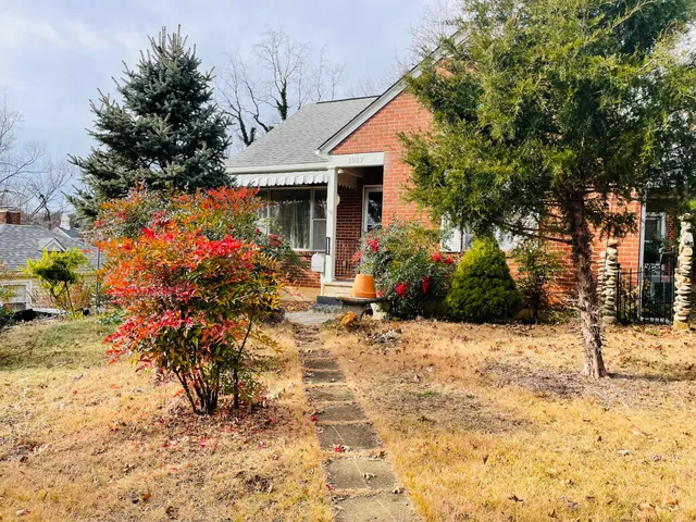 a front view of a house with a yard covered with snow