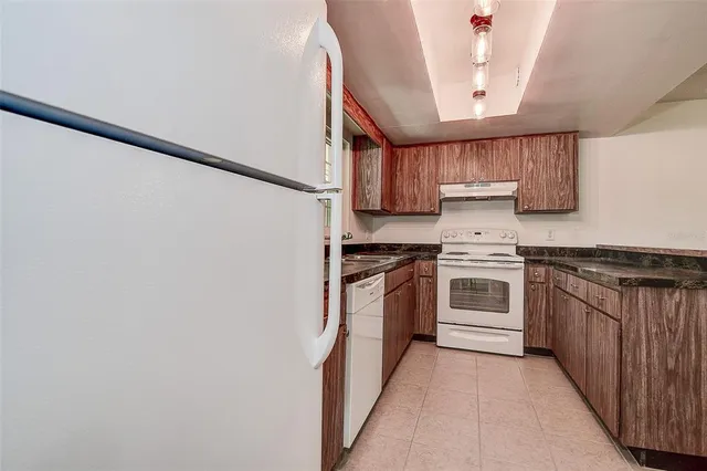 a kitchen with granite countertop a sink stove and cabinets