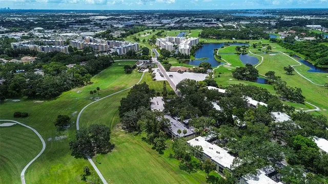 a front view of a building with a garden and trees