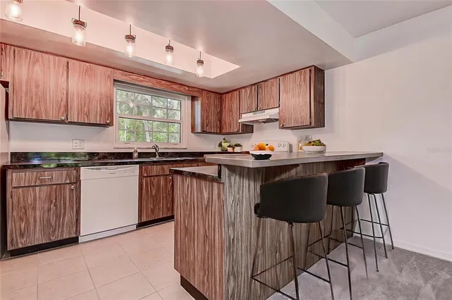 a kitchen with granite countertop a stove sink and cabinets