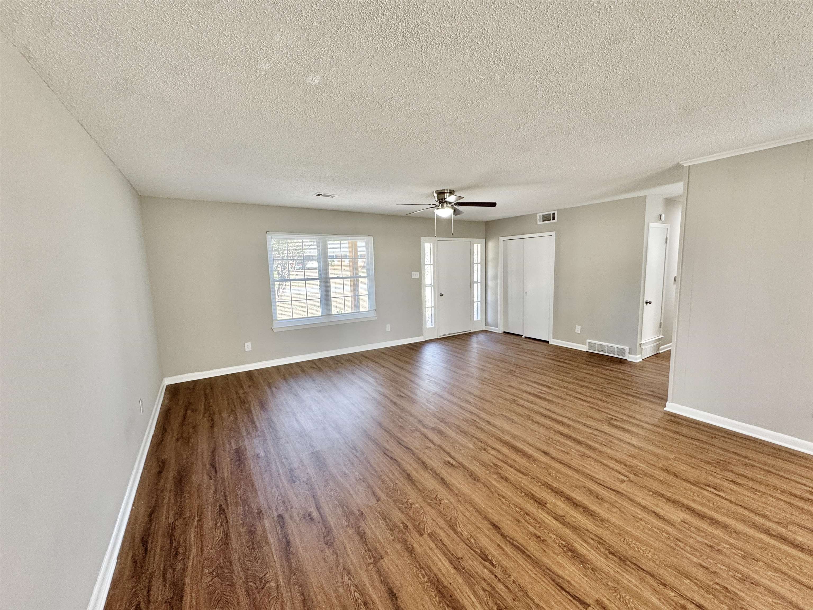 5095 Bowie Road Memphis, TN 38109 - Photo 11 of 25 Unfurnished room featuring a textured ceiling, wood finished floors, and ceiling fan