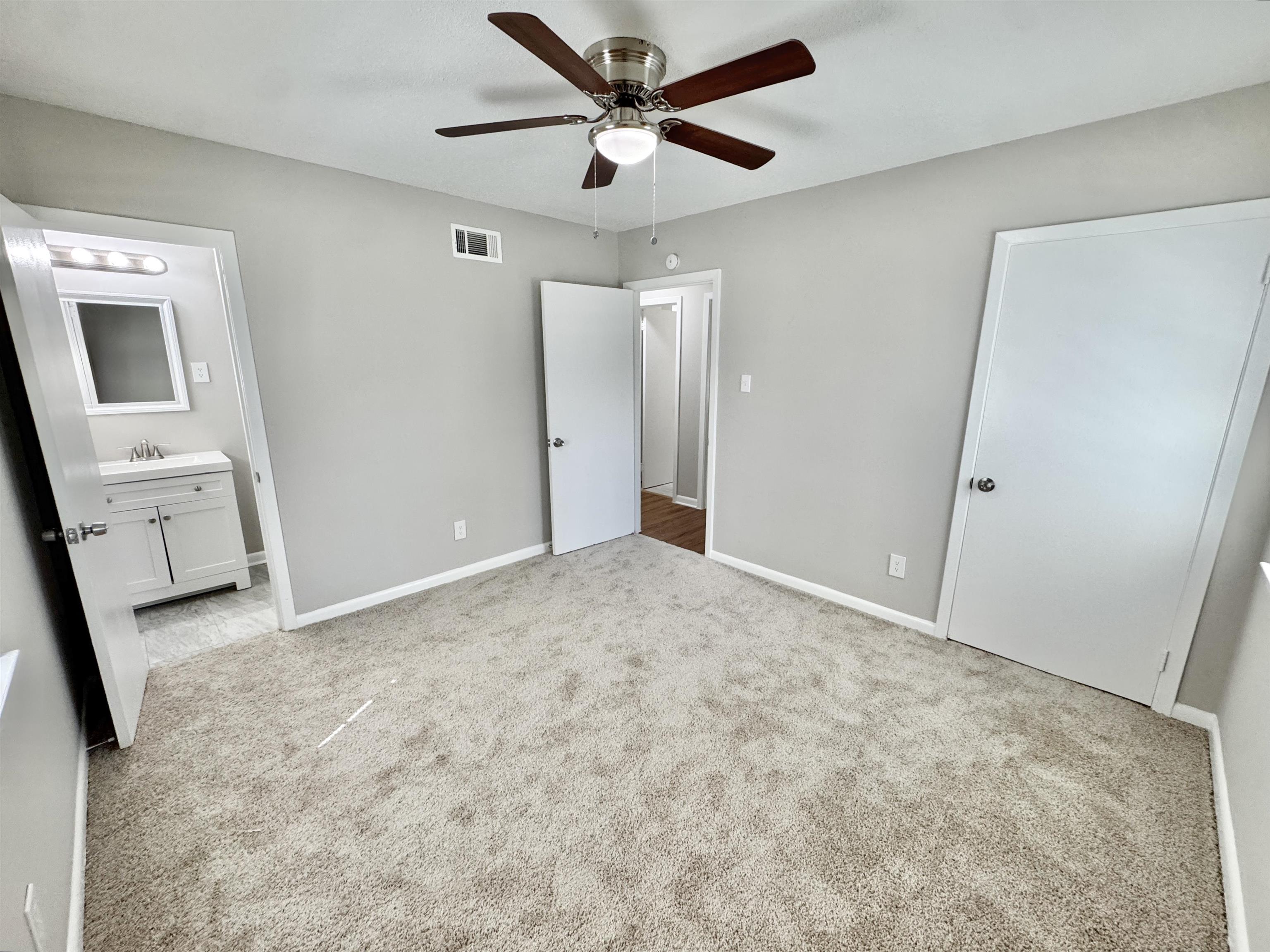 5095 Bowie Road Memphis, TN 38109 - Photo 14 of 25 Unfurnished bedroom with light colored carpet, ceiling fan, and ensuite bathroom