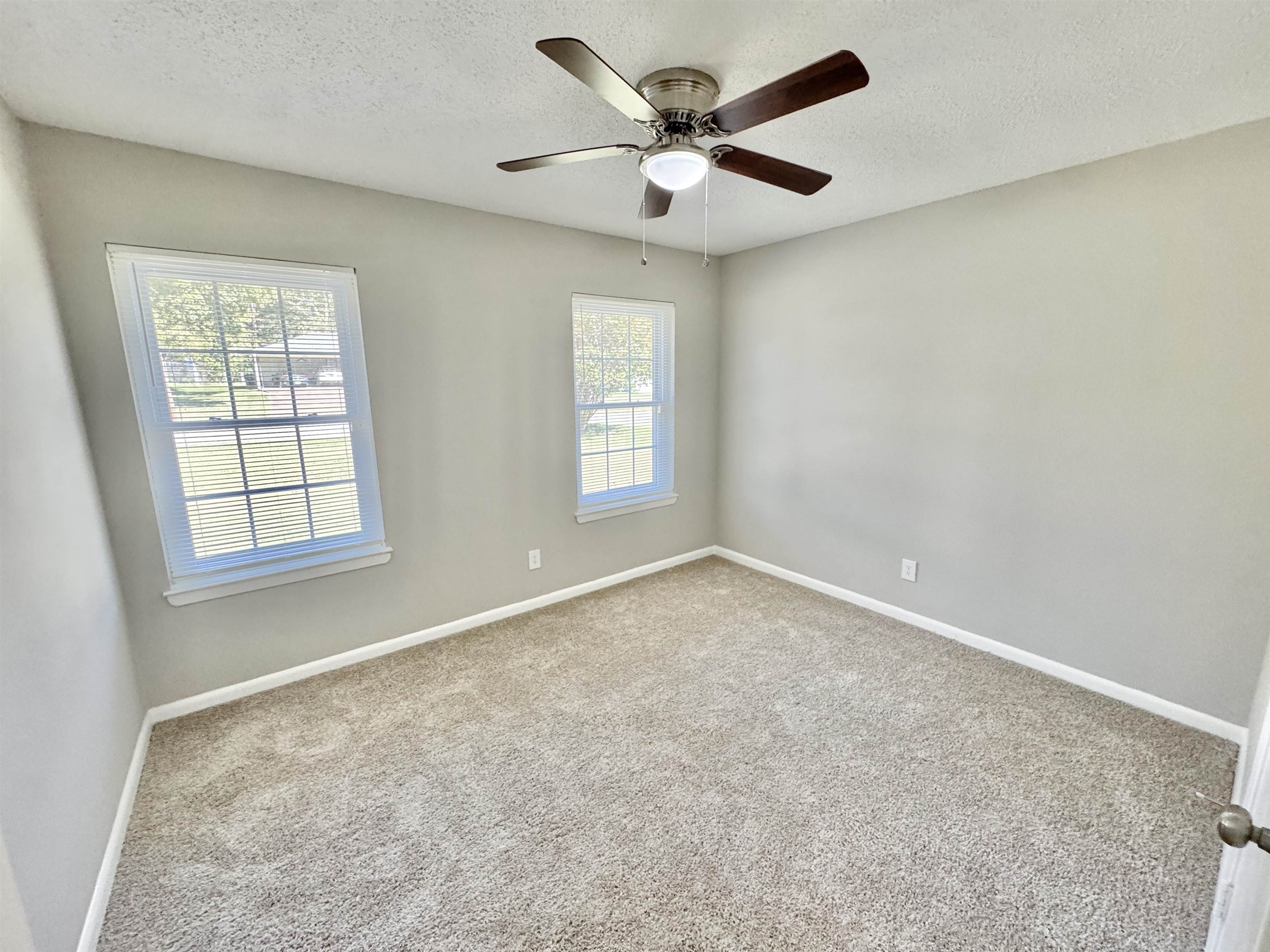 5095 Bowie Road Memphis, TN 38109 - Photo 19 of 25 Carpeted empty room featuring healthy amount of natural light, a textured ceiling, and a ceiling fan
