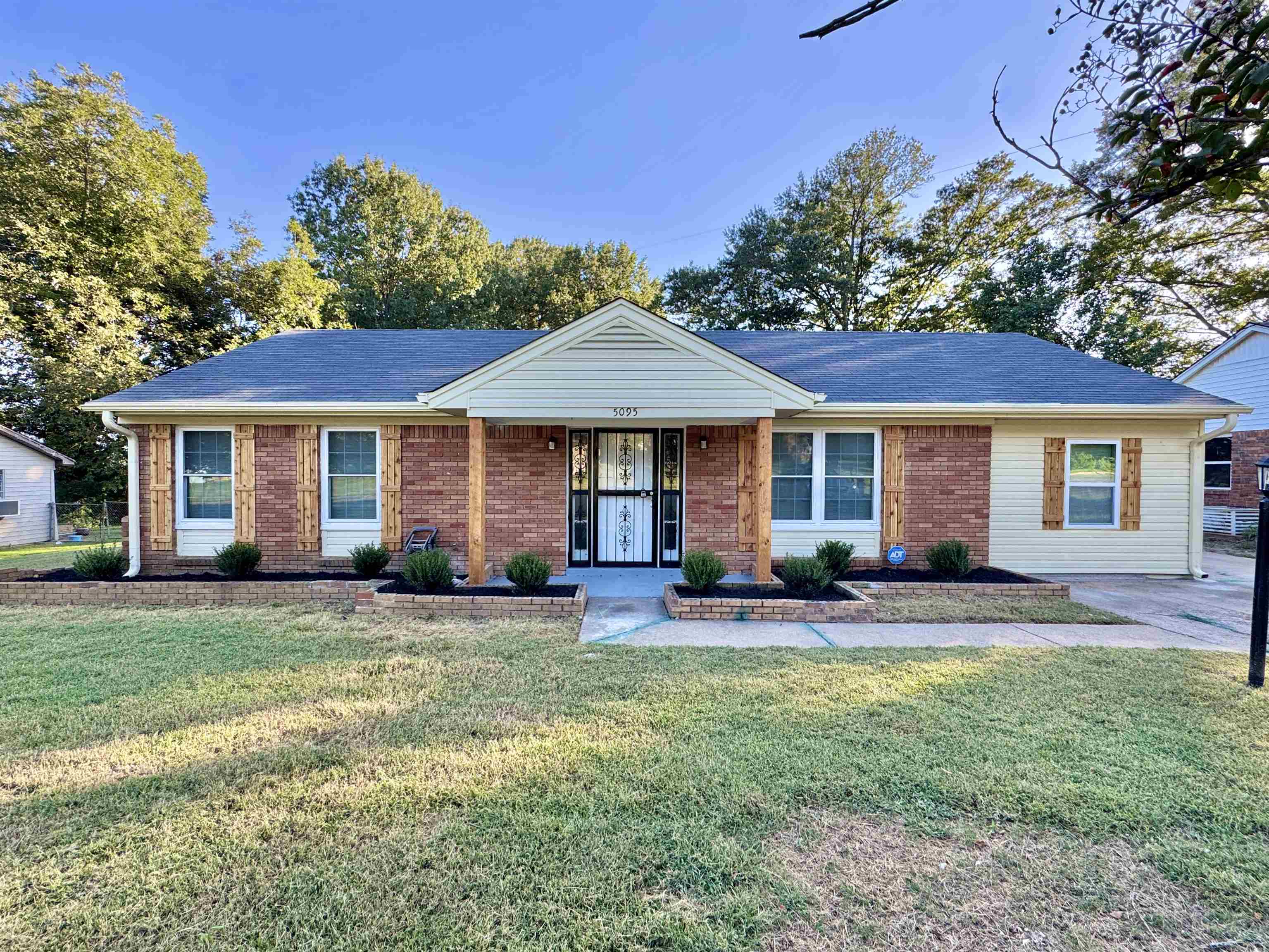5095 Bowie Road Memphis, TN 38109 - Photo 4 of 25 Ranch-style house with a front lawn, brick siding, and a porch