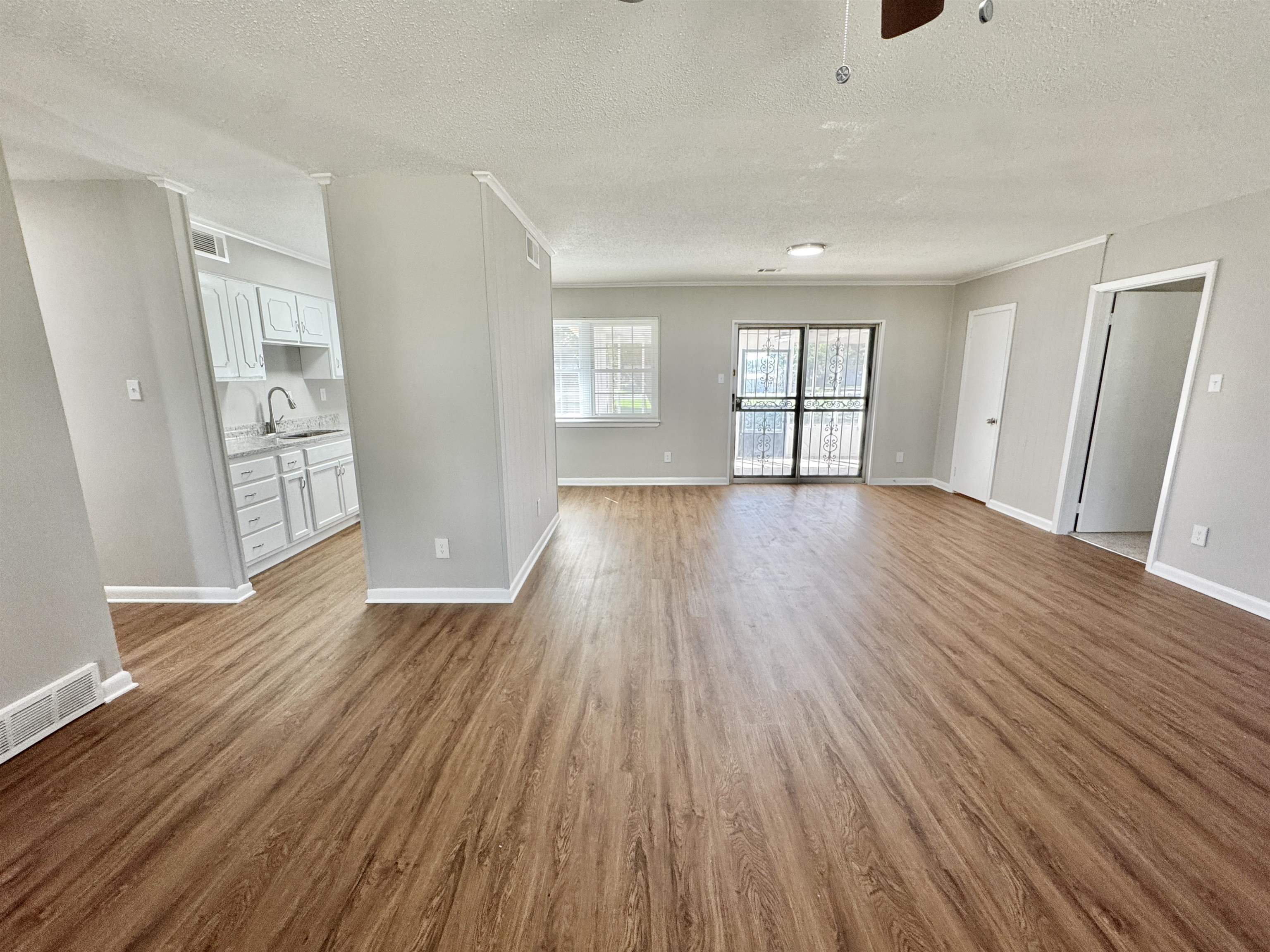 5095 Bowie Road Memphis, TN 38109 - Photo 9 of 25 Unfurnished living room featuring a textured ceiling, light wood-style flooring, and a ceiling fan