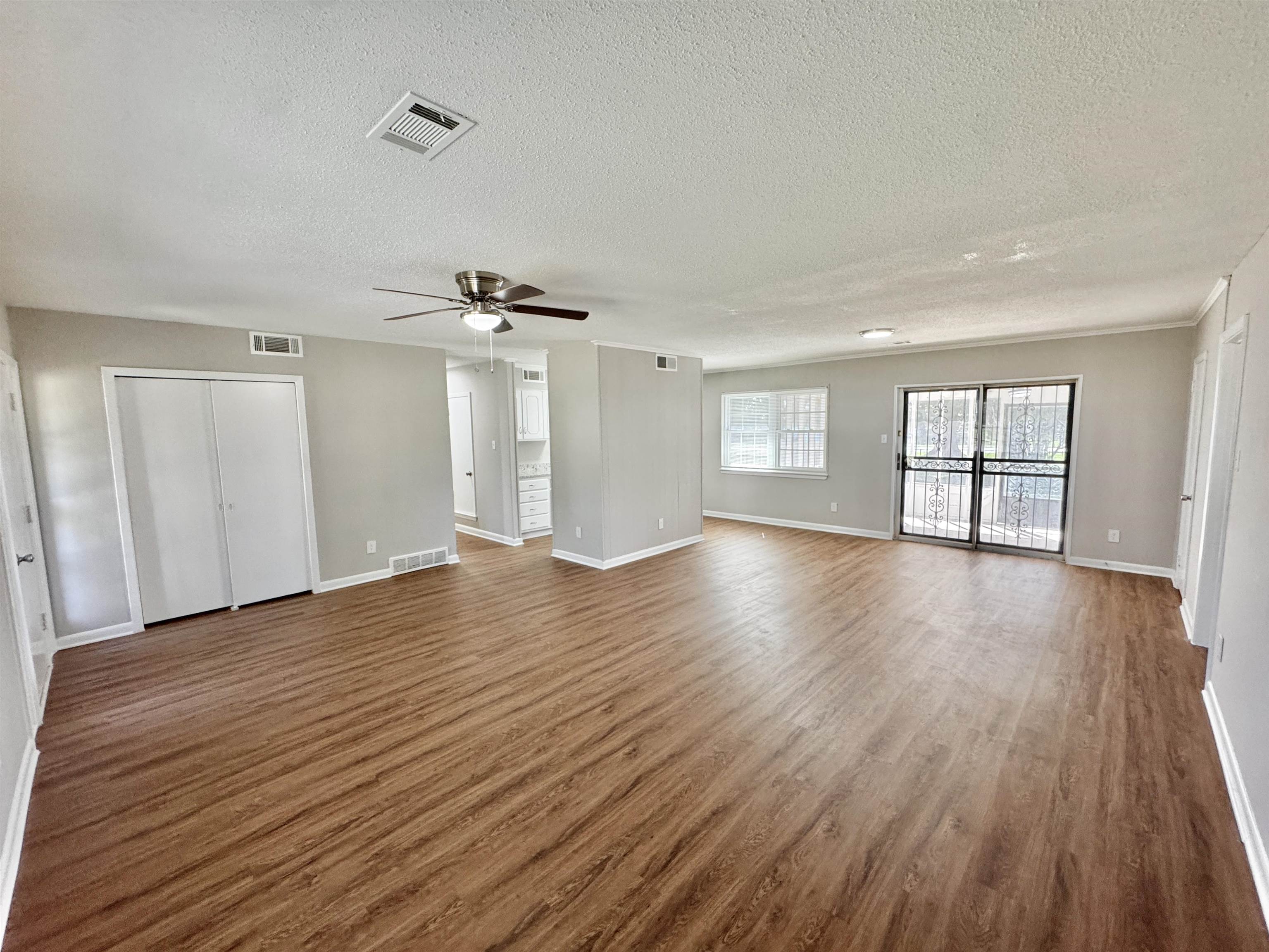 5095 Bowie Road Memphis, TN 38109 - Photo 10 of 25 Unfurnished living room with a textured ceiling, wood finished floors, and ceiling fan