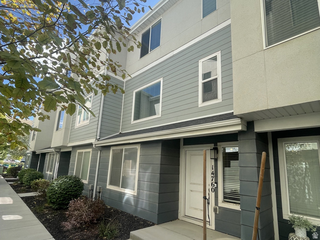 14760 Rising Star Way, Unit 71 Bluffdale, UT 84065 - Photo 1 of 41 Multi-story townhouse exterior with a white entry door, contemporary wall-mounted lighting, and a concrete walkway