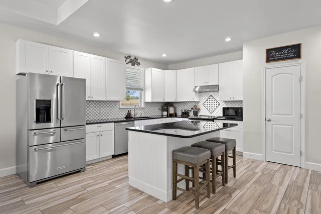 a kitchen with white cabinets and stainless steel appliances