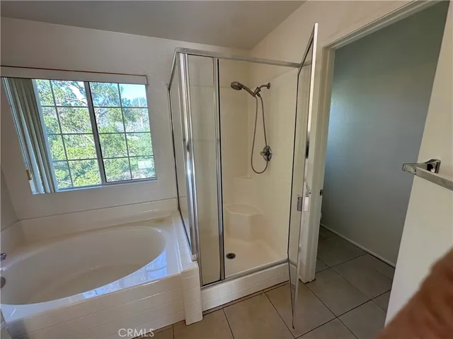 a bathroom with a tub a sink and a large window
