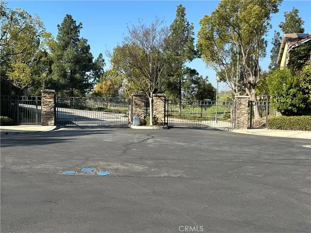 a view of a patio with table and chairs and potted plants and large trees