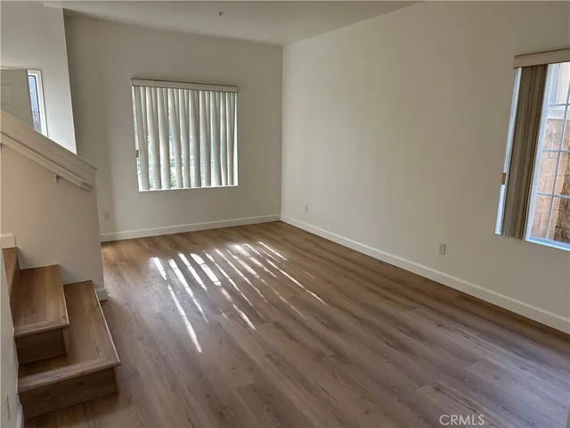 an empty room with wooden floor and fireplace