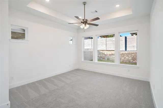 en empty room with windows and ceiling fan