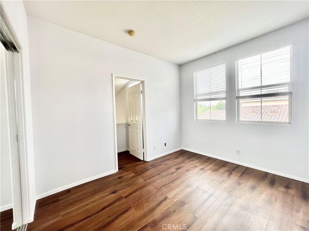 1307 Elmhurst Irvine, CA 92618 - Photo 12 of 14 an empty room with wooden floor and windows