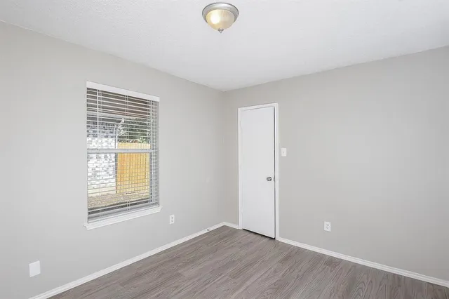 an empty room with windows and closet