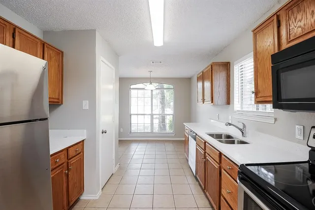 a kitchen with stainless steel appliances a sink stove and refrigerator