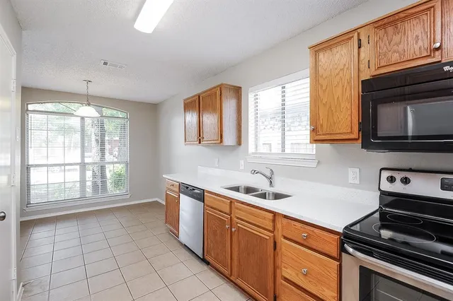 a kitchen with a sink a stove cabinets and counter space