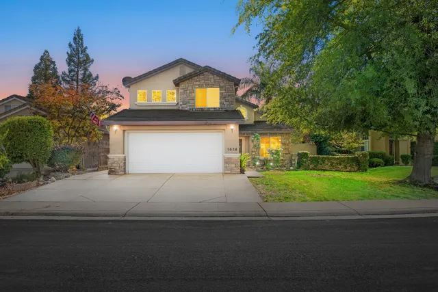 a front view of a house with a yard and garage