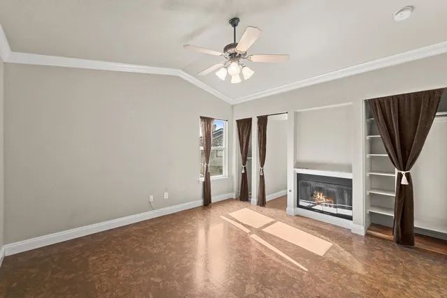 a view of livingroom with a fireplace a ceiling fan and wooden floor