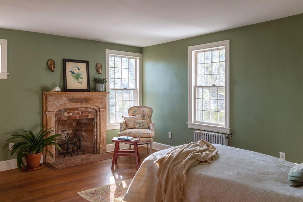 168 Argilla Road Ipswich, MA 01938 - Photo 25 of 32 a bedroom with a bed and a fireplace