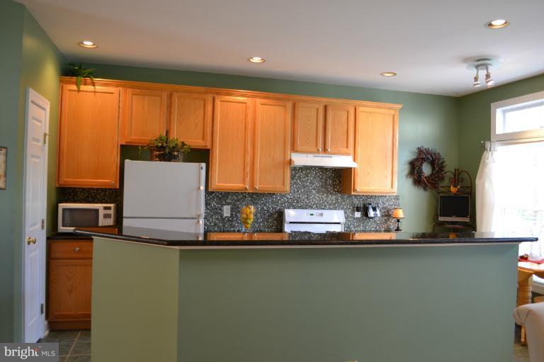 6650 Debra Lu Way Springfield, VA 22150 - Photo 12 of 25 a kitchen with kitchen island a sink a stove and a window