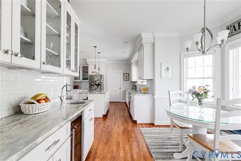 a very nice looking open kitchen with stainless steel appliances granite countertop a lot of counter space and a wooden floor