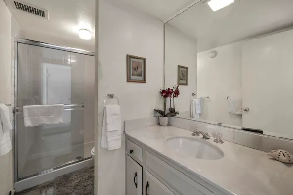 a spacious bathroom with a double vanity sink a large mirror a shower and a bathtub