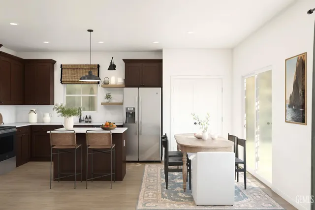 a kitchen with stainless steel appliances kitchen island granite countertop a table chairs microwave and sink