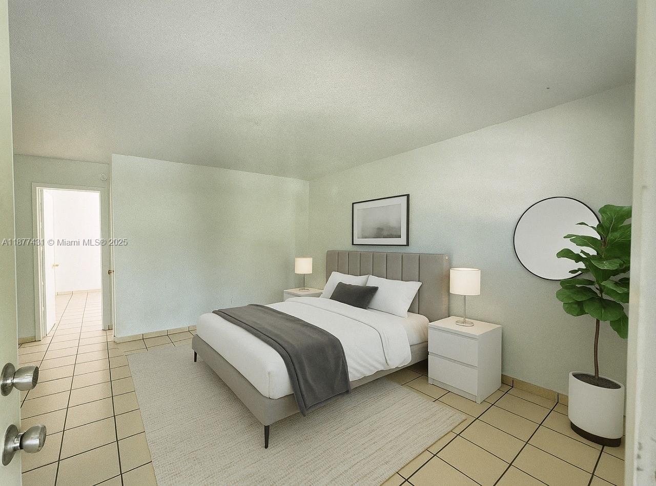 855 West 29th Street, Unit 19 Hialeah, FL 33012 - Photo 5 of 8 a bedroom with a bed and a potted plant