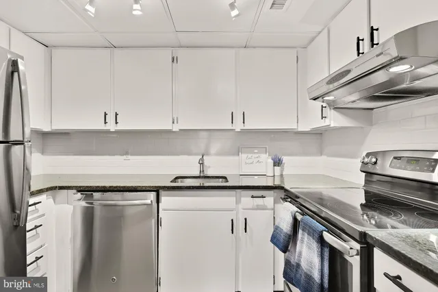 a kitchen with stainless steel appliances granite countertop a sink stove and cabinets