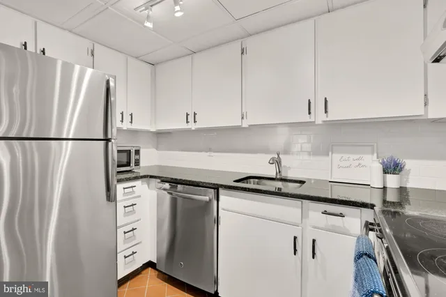 a kitchen with stainless steel appliances a refrigerator sink and cabinets