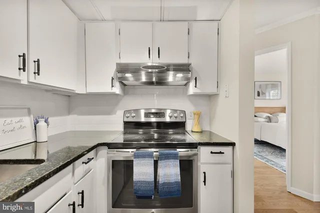 a kitchen with stainless steel appliances granite countertop a sink stove and cabinets