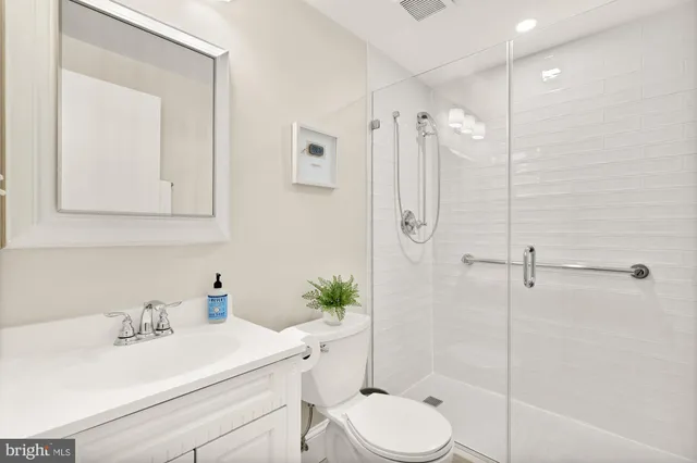 a bathroom with a sink toilet a mirror and shower