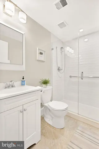 a bathroom with a granite countertop sink toilet and shower
