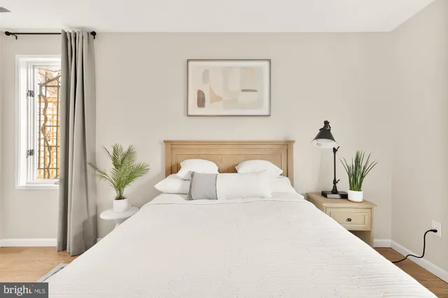 a bedroom with a large bed and a potted plant