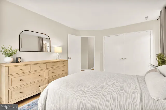 a bedroom with a bed and a mirror on dresser