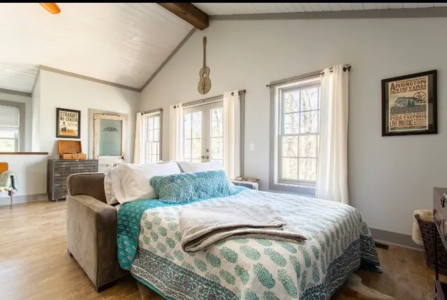 a spacious bedroom with a bed and glass windows