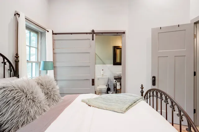 a bedroom with a bed and wooden floor