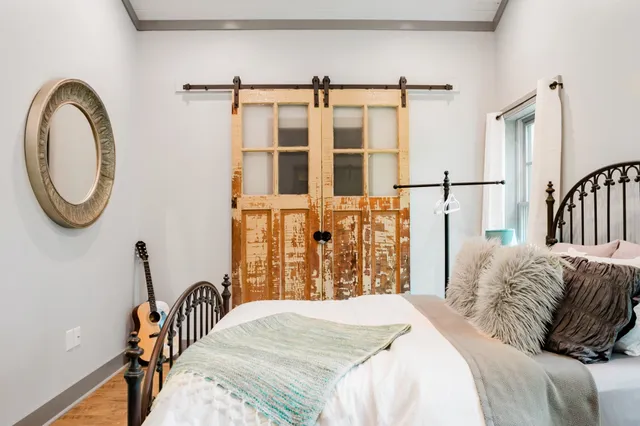 a bedroom with a bed and a large mirror