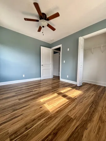 en empty room with wooden floor and windows