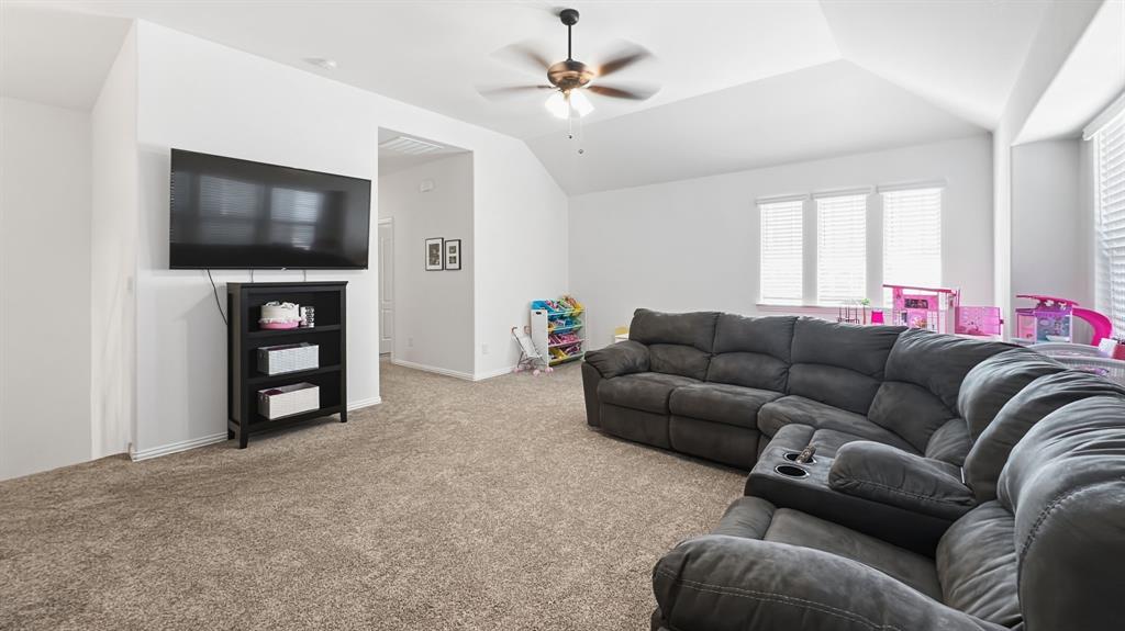 5216 Troupe Road McKinney, TX 75071 - Photo 25 of 40 Spacious room featuring vaulted ceilings, a ceiling fan with integrated lighting, triple windows with blinds, and neutral carpeting