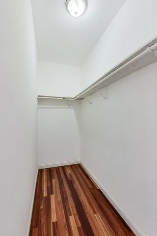 a view of a room with wooden floor and small window