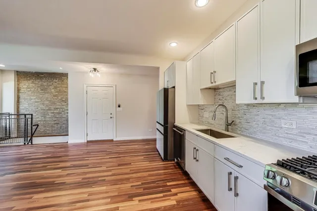 a kitchen with stainless steel appliances a sink stove top oven and cabinets