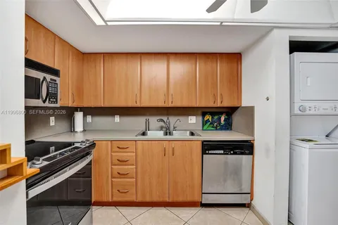 a kitchen with stainless steel appliances granite countertop a stove a sink and white cabinets